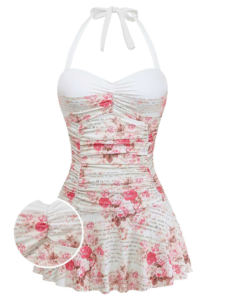 Ein weißer, einteiliger Badeanzug mit rosa Rosenmuster, Vintage-Schriftzug, herzförmigem Ausschnitt und angenähtem Rüschen-Schwimmrock.