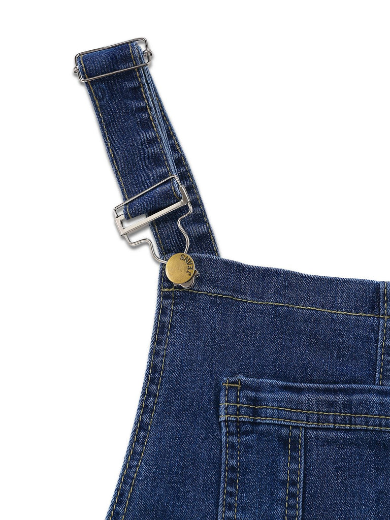 Nahaufnahme einer blauen Jeans-Latzhose mit Hosenträgern vor weißem Hintergrund