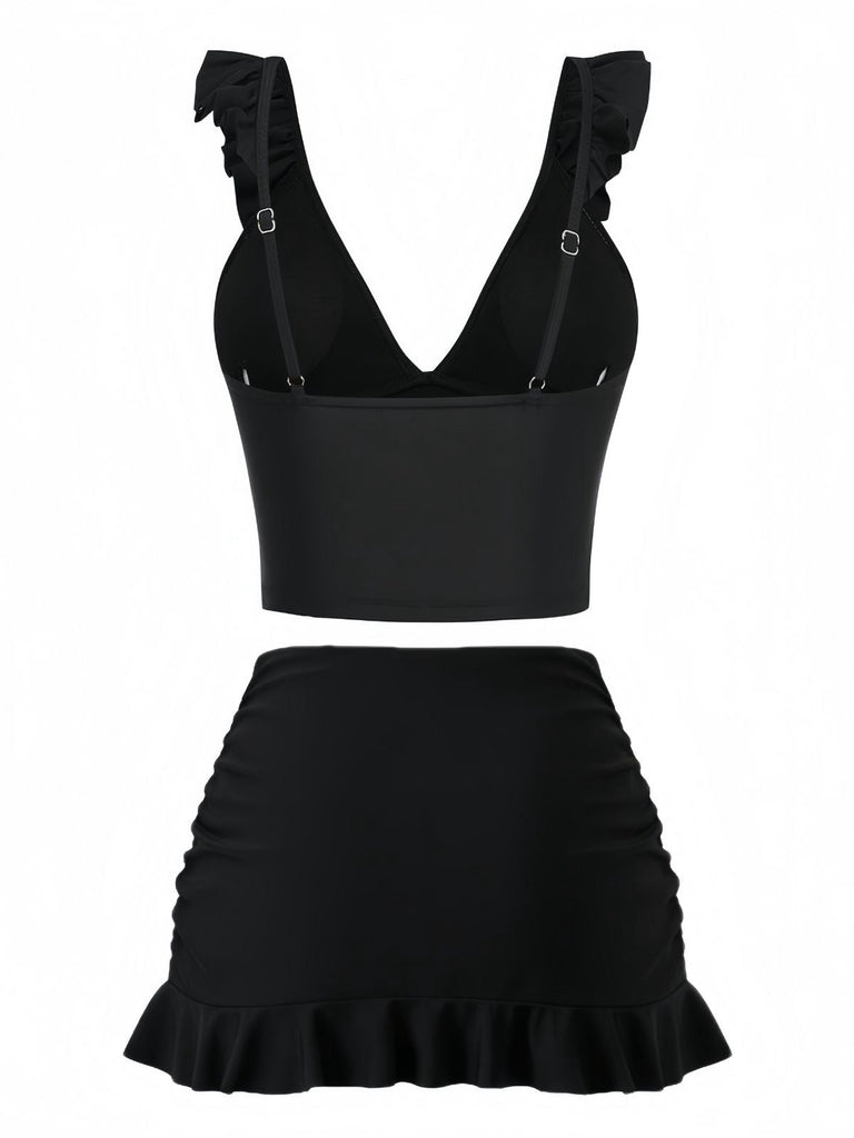 Schwarzes zweiteiliges Outfit mit Rüschenoberteil und -rock auf weißem Hintergrund