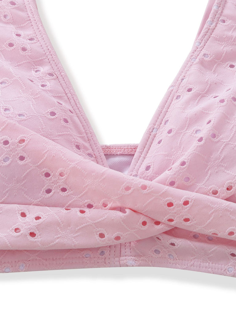 Nahaufnahme eines rosa BHs mit Ösenverzierungen auf weißem Hintergrund