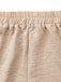 Nahaufnahme von beigen Shorts mit Fokus auf den Bund und die Stoffstruktur.