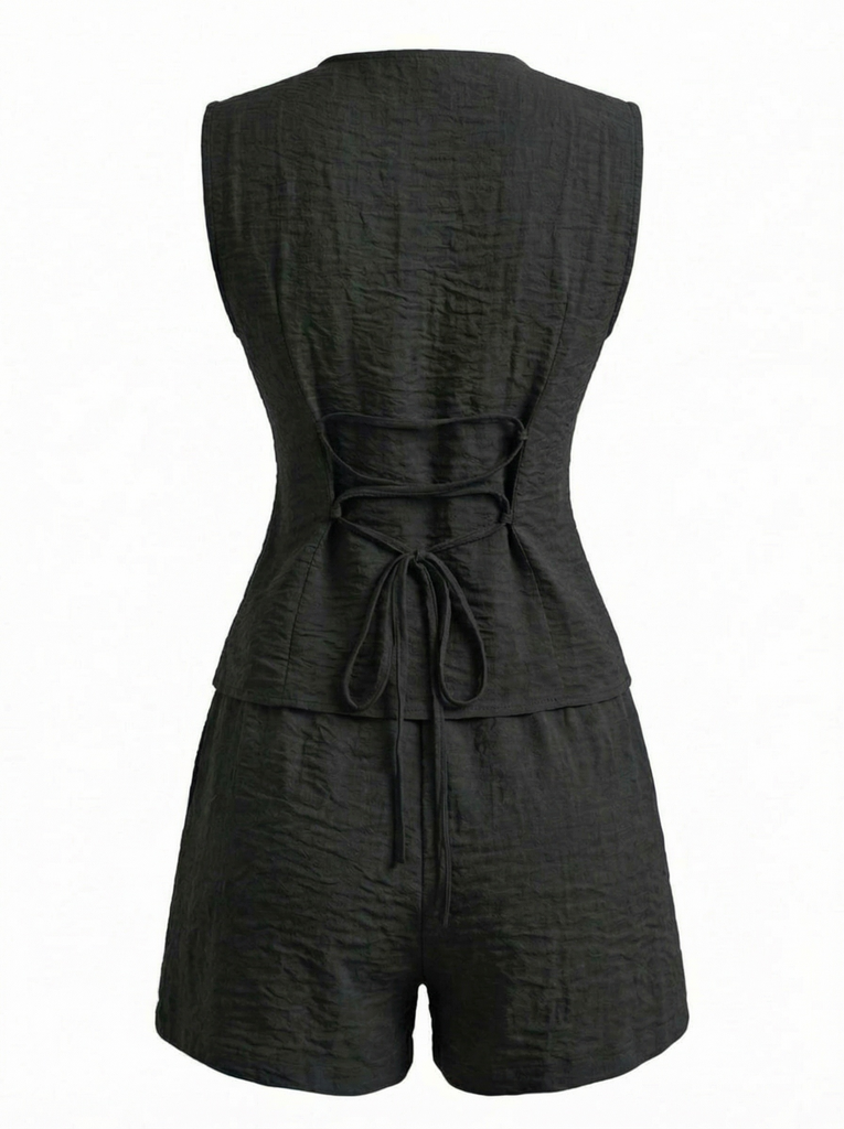 Schwarzer Jumpsuit mit Bindegürtel auf weißem Hintergrund