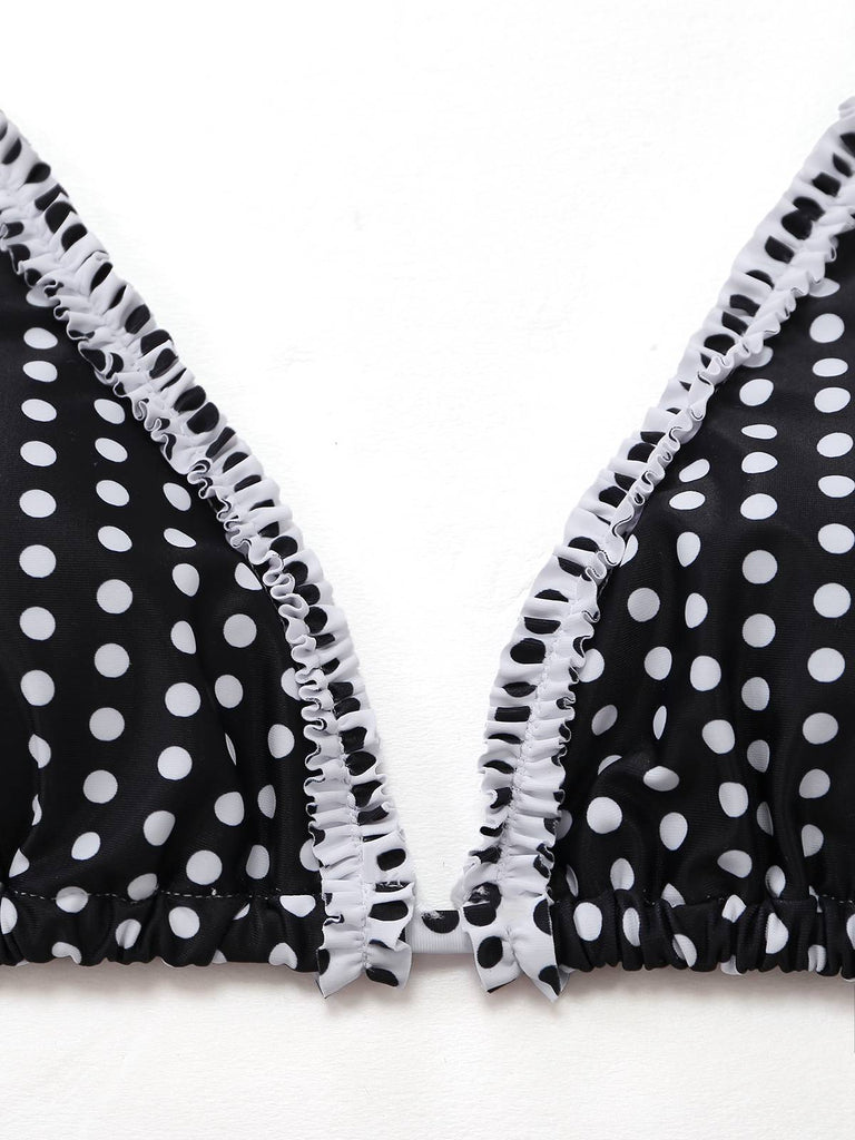 Schwarzes Bikini-Oberteil mit weißen Punkten und Rüschenkanten auf weißem Hintergrund