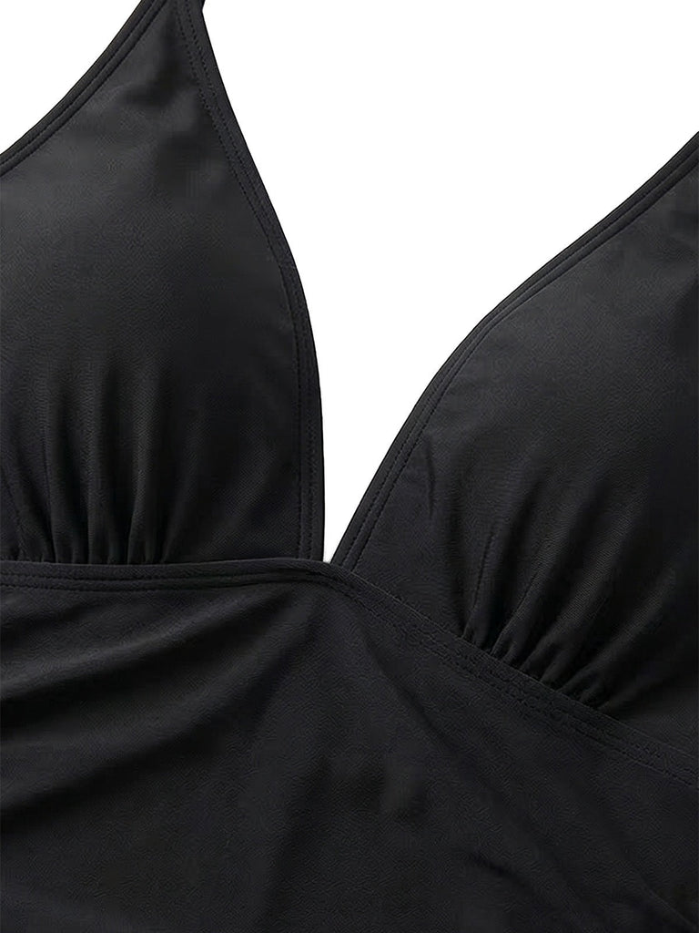 Nahaufnahme eines schwarzen Badeanzugoberteils vor weißem Hintergrund