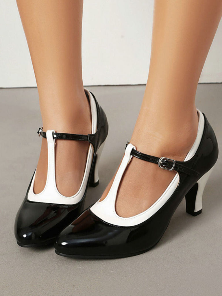 Schwarze und weiße High Heels auf neutralem Hintergrund