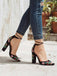 Schwarze Schuhe mit Blockabsatz und Blumenstickerei, getragen zu blauen Jeans vor hellem Hintergrund.