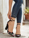 Schwarze, blumengemusterte Pumps, getragen zu hochgekrempelten Jeans.