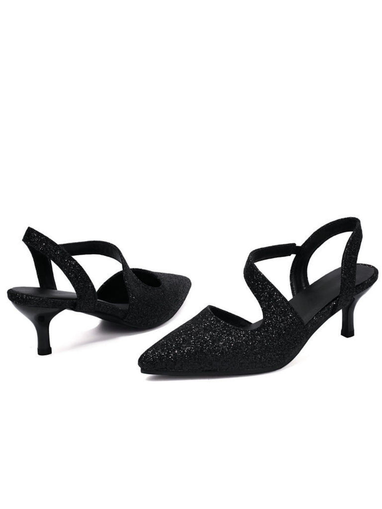 Schwarze, glitzernde High Heels auf weißem Hintergrund