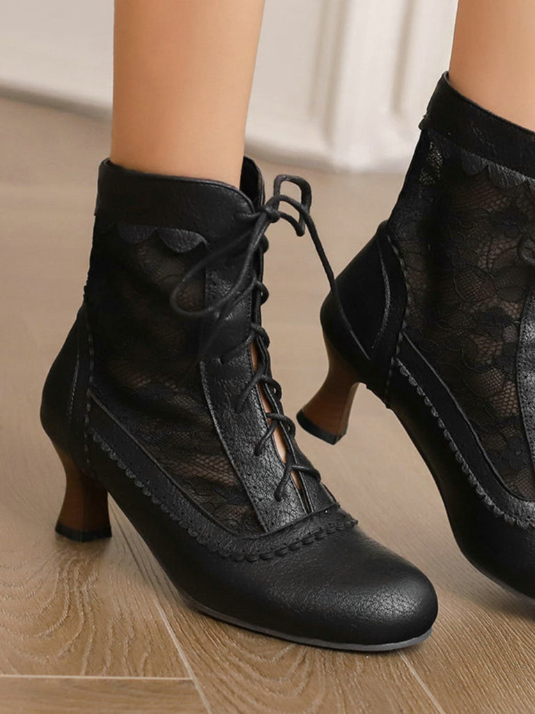 Schwarze Schnürschuhe, getragen von einer Person auf einem Holzboden.