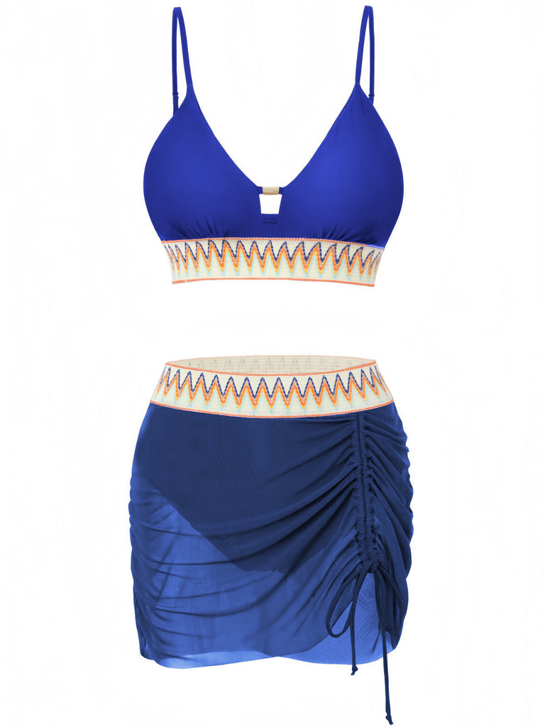 Blaues Bikini-Set mit gerafftem Rock auf weißem Hintergrund