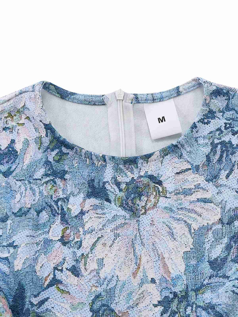 Nahaufnahme eines blauen Blumenkleides mit Markenetikett auf weißem Hintergrund