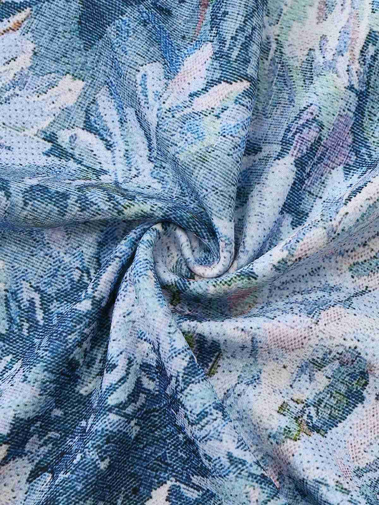 Nahaufnahme eines strukturierten Stoffes mit floralem Muster in Blau, Weiß und Rosa.