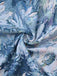 Nahaufnahme eines strukturierten Stoffes mit floralem Muster in Blau, Weiß und Rosa.