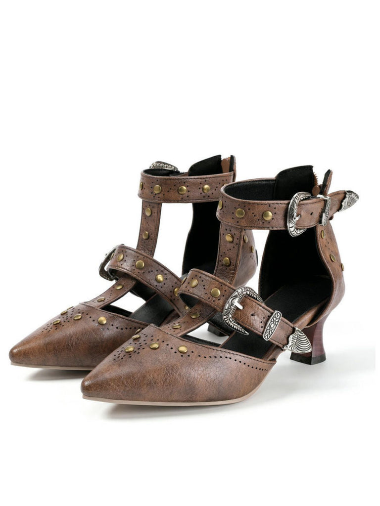 Ein Paar braune Lederschuhe mit Schnallen und Nieten auf weißem Hintergrund