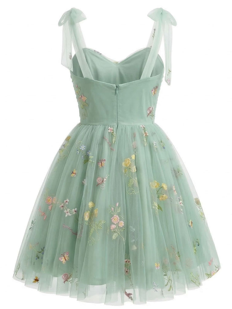 Hellgrünes Kleid mit Blumenstickerei auf weißem Grund