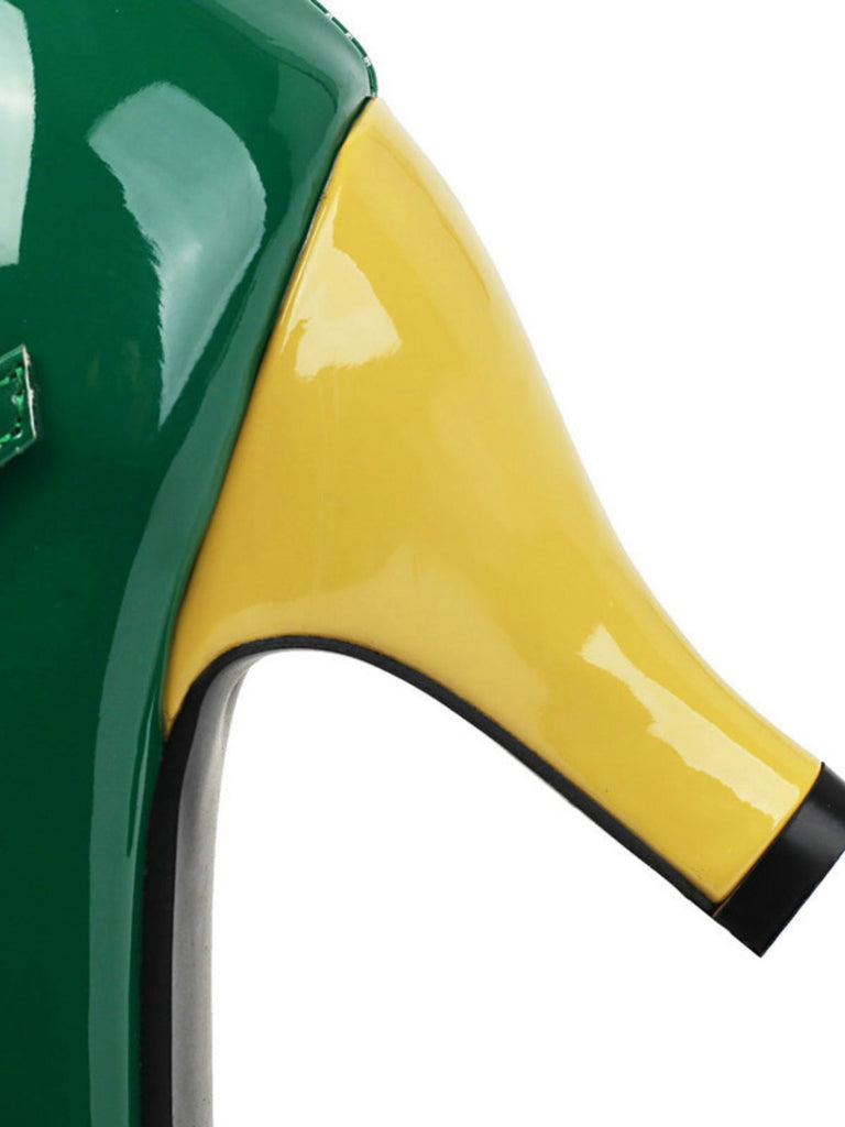 Nahaufnahme eines grün-gelben High Heels mit schwarzer Sohle.