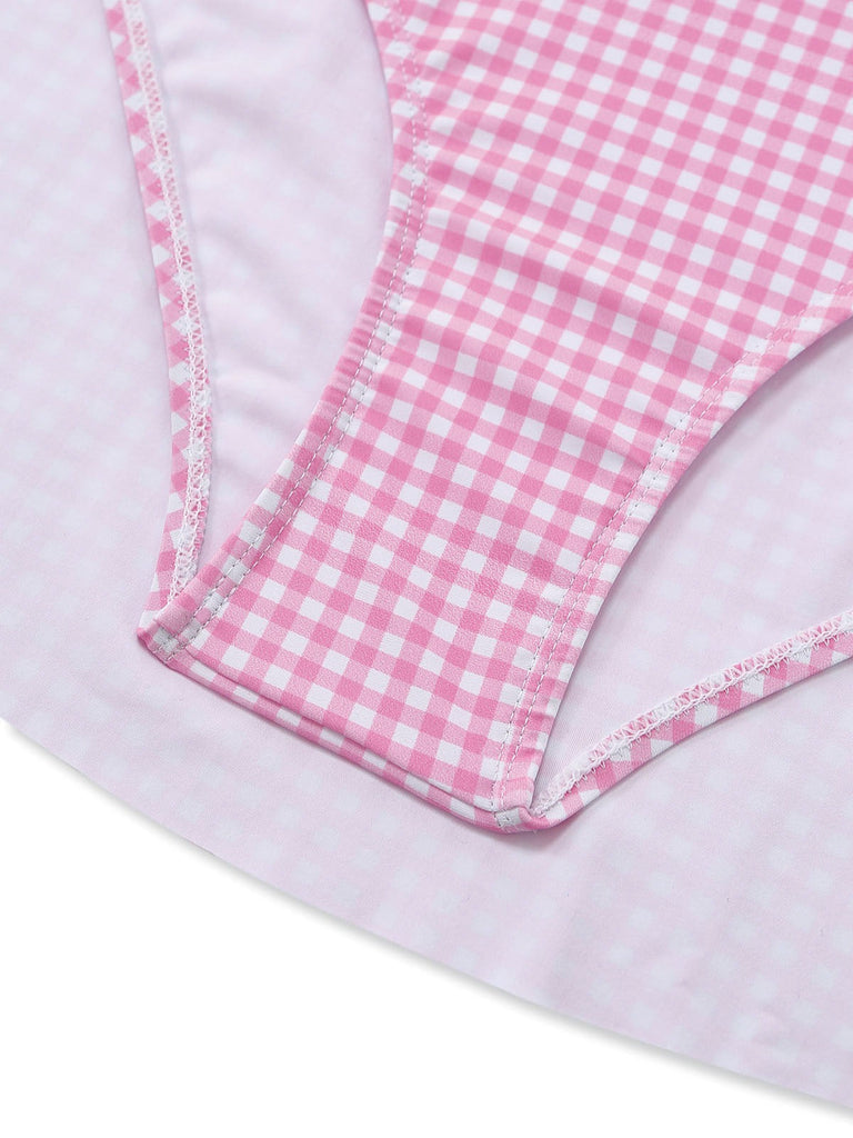 Nahaufnahme eines rosa-weiß karierten Stoffes vor hellviolettem Hintergrund