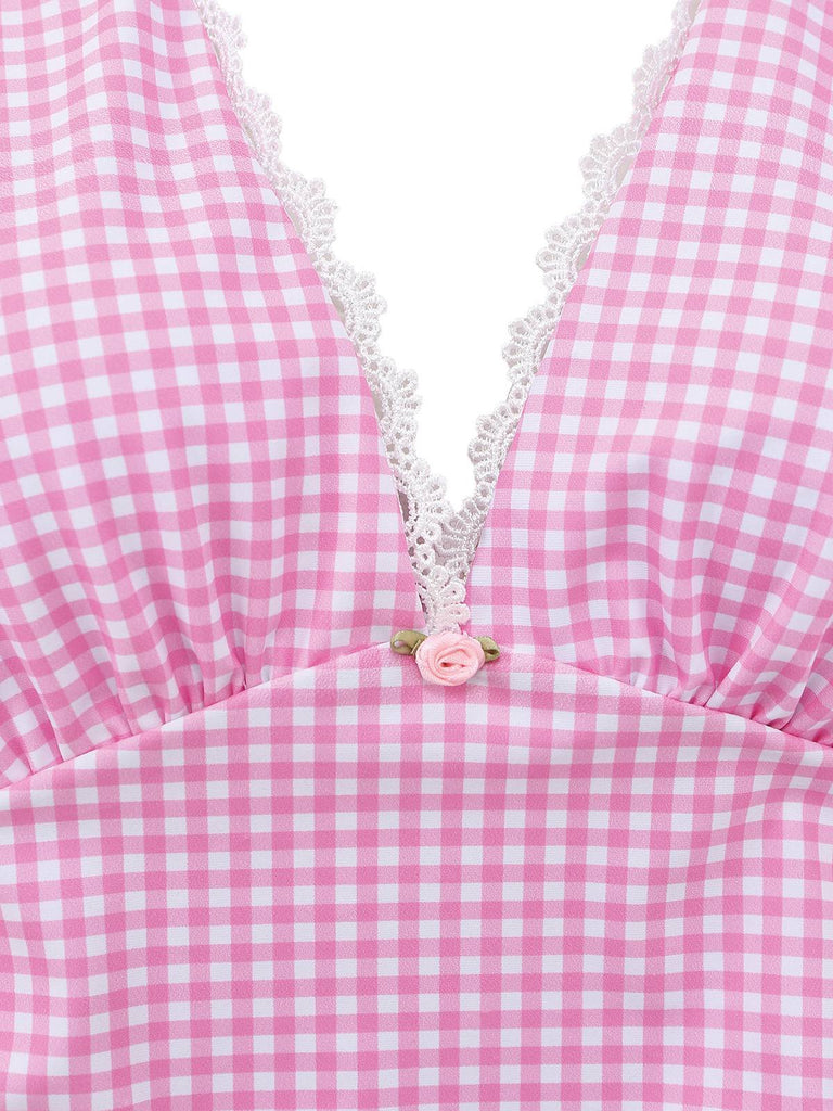 Nahaufnahme eines rosa-weiß karierten Kleides mit Spitzenbesatz und Blumenapplikation.