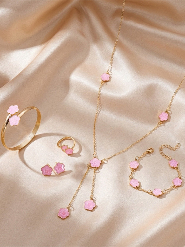 Rosa Schmuckset mit rosa Edelsteinen auf beigefarbenem Stoffhintergrund