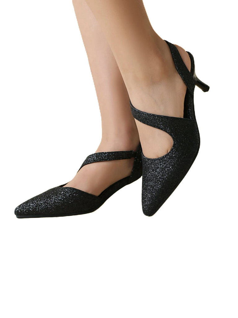 Schwarze Glitzerschuhe, getragen von einer Person vor weißem Hintergrund