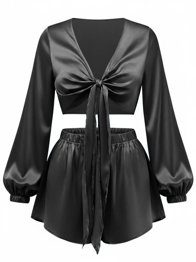 Das zweiteilige Set aus seidigem Satin mit Bindebändern vorne ist in klassischem Schwarz gehalten und sorgt für einen eleganten Lounge-Look.