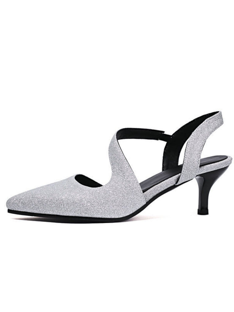 Silberglitzernde High Heels mit schwarzen Riemchen auf weißem Hintergrund