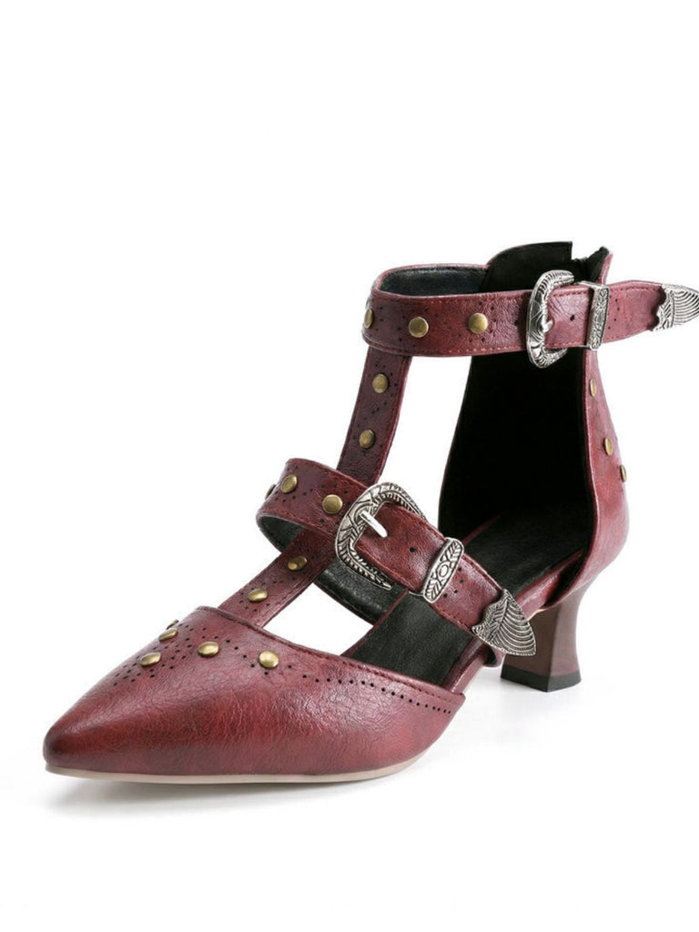 Roter High Heel mit Schnallen und Nieten auf weißem Hintergrund