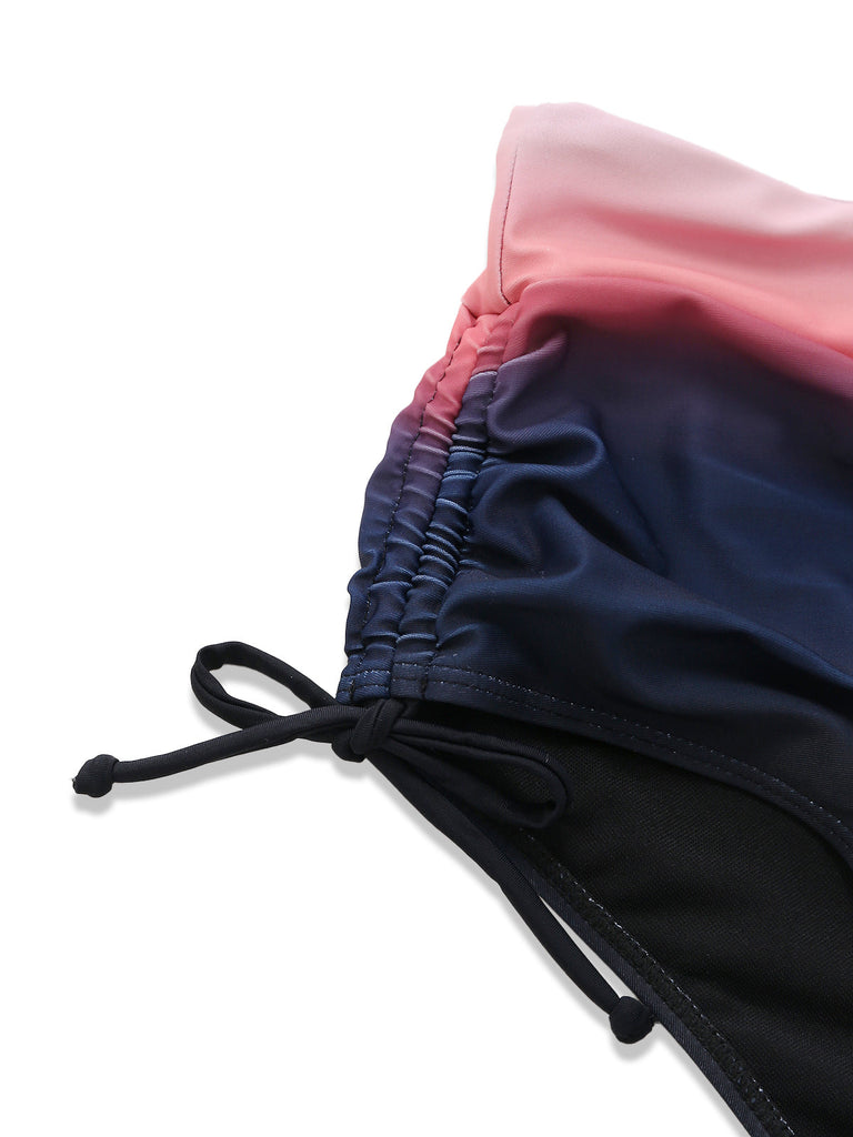 Detailaufnahme des seitlichen Bindebandverschlusses und der gerafften Details an der hochgeschnittenen, marineblauen Bikinihose.