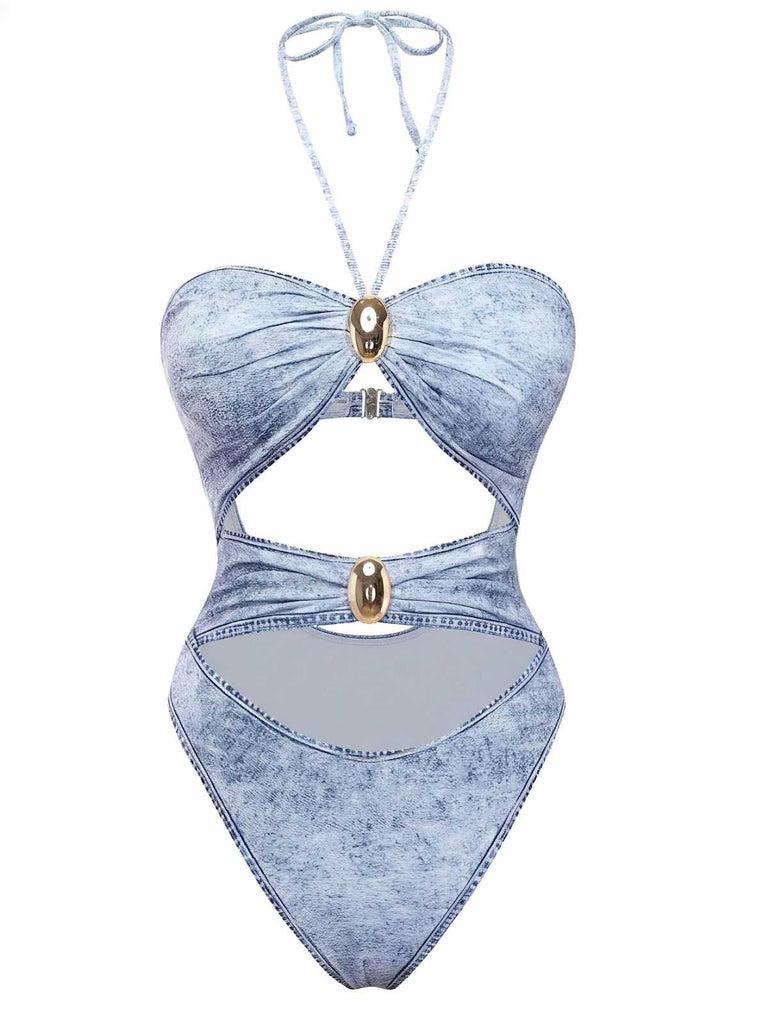 Ein hellblauer, einteiliger Badeanzug mit Denim-Print, Neckholder-Ausschnitt, mehreren Ausschnitten vorne und dekorativen goldfarbenen Metallapplikationen.