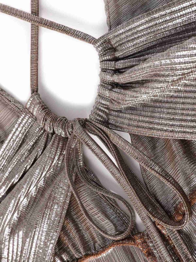 Nahaufnahme eines metallisch glänzenden Stoffes mit aufwendigen Mustern und Texturen.