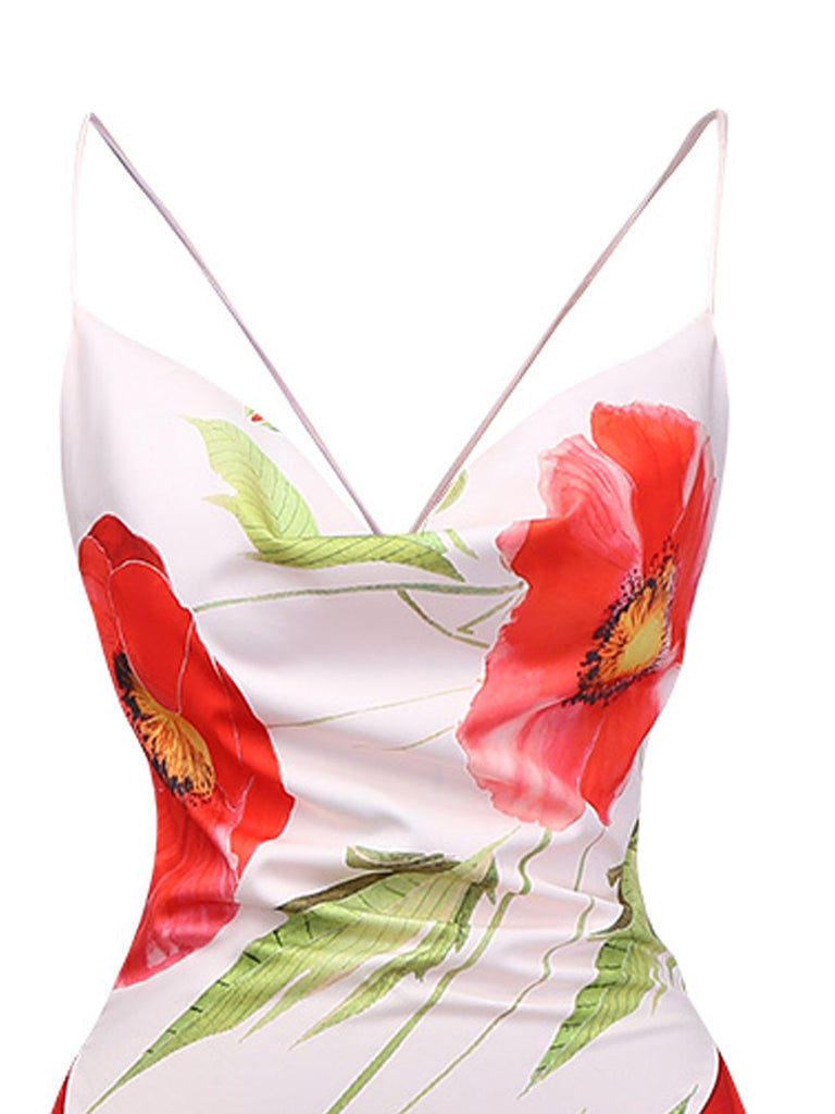 Nahaufnahme des elegant drapierten Wasserfallausschnitts und der zarten Spaghettiträger des geblümten Midikleids.