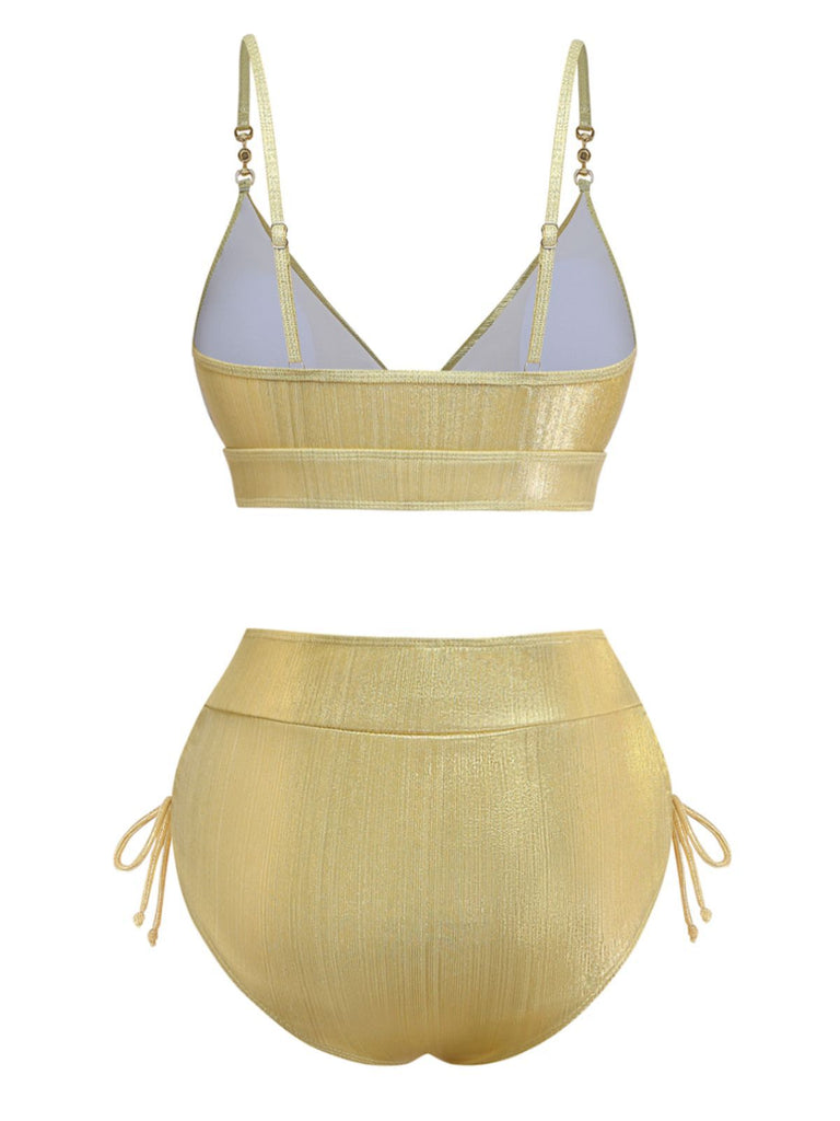 Rückansicht des goldfarbenen Metallic-Bikini-Sets, die das hochgeschnittene Höschen mit vollständiger Bedeckung und das Oberteil mit Rückenschnürung zeigt.
