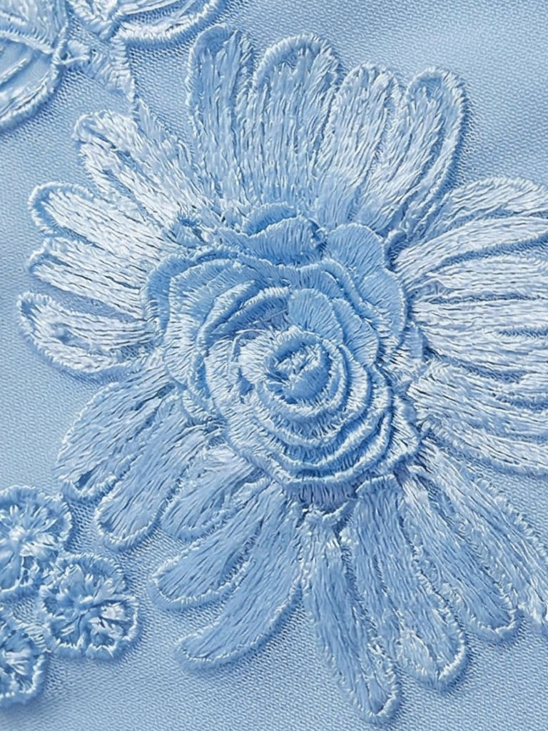 Makroansicht der detaillierten, dreidimensional wirkenden floralen Spitzenapplikationen, die auf dem gesamten Kleid verarbeitet wurden.