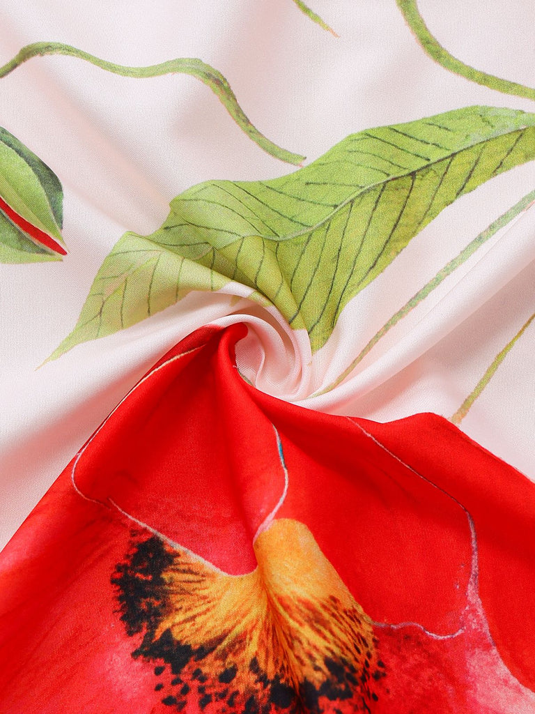 Makroaufnahme des hochauflösenden Drucks aus roter Blume und grünem Blatt auf weichem, glattem, weißem Stoff.