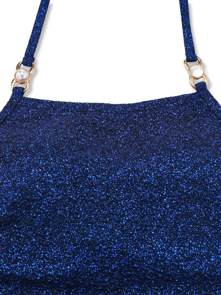 Nahaufnahme des quadratischen Ausschnitts und der goldfarbenen Beschläge auf dem schimmernden marineblauen Stoff.