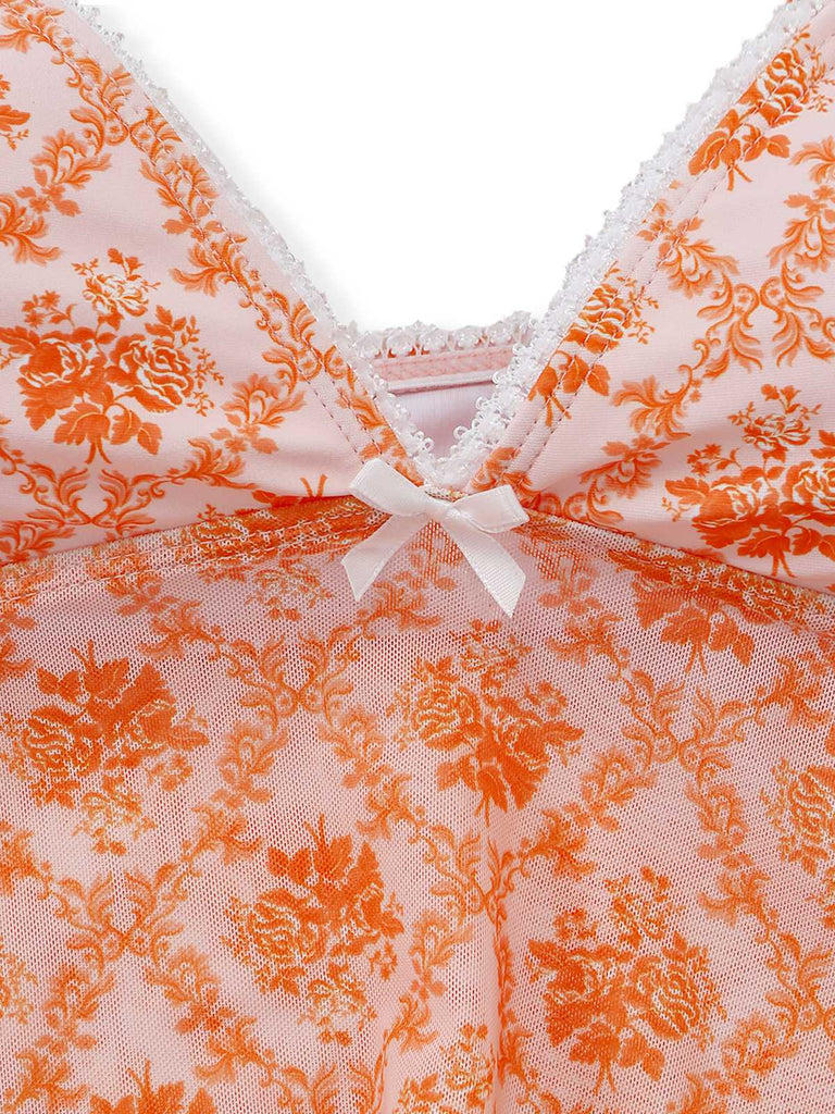 Nahaufnahme eines rosa Spitzenkleidungsstücks mit orangefarbenen Blumenmustern und einer weißen Schleife.