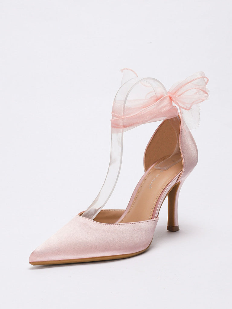 Rosafarbener High Heel mit Schleife auf hellgrauem Hintergrund