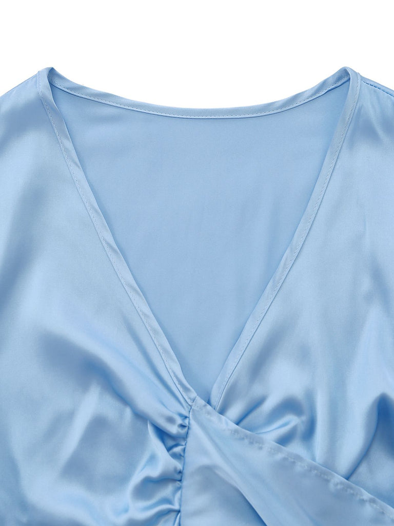 Nahaufnahme des eleganten, tiefen V-Ausschnitts und des glatten Satins des hellblauen, kurzen Loungetops.