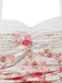 Detailaufnahme des gerafften herzförmigen Ausschnitts und des zarten rosa Blumenmusters.