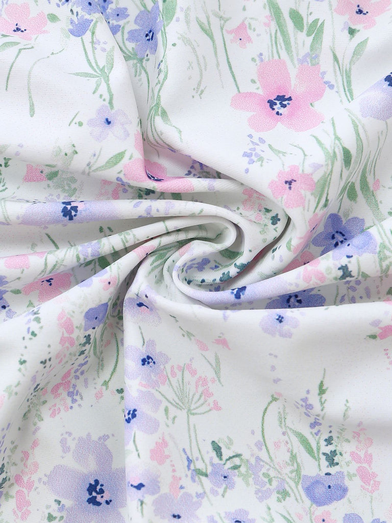 Geblümter Stoff mit rosa, lila und grünen Blüten auf weißem Hintergrund