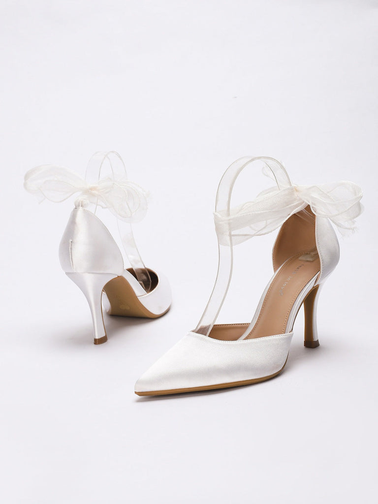 Weiße High Heels mit Schleifenverzierungen auf weißem Hintergrund